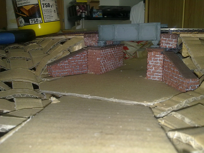 24082013092.jpg - Die Brücke ist in die Anlage eingebaut, das Gleis wurde verlegt und das Grundgerüst für die Landschaft aus den geflochtenen Papstreifen ist vorhanden. Für die Straße (Feldweg) wurde als Untergrund auch Wellpappe verwendet.