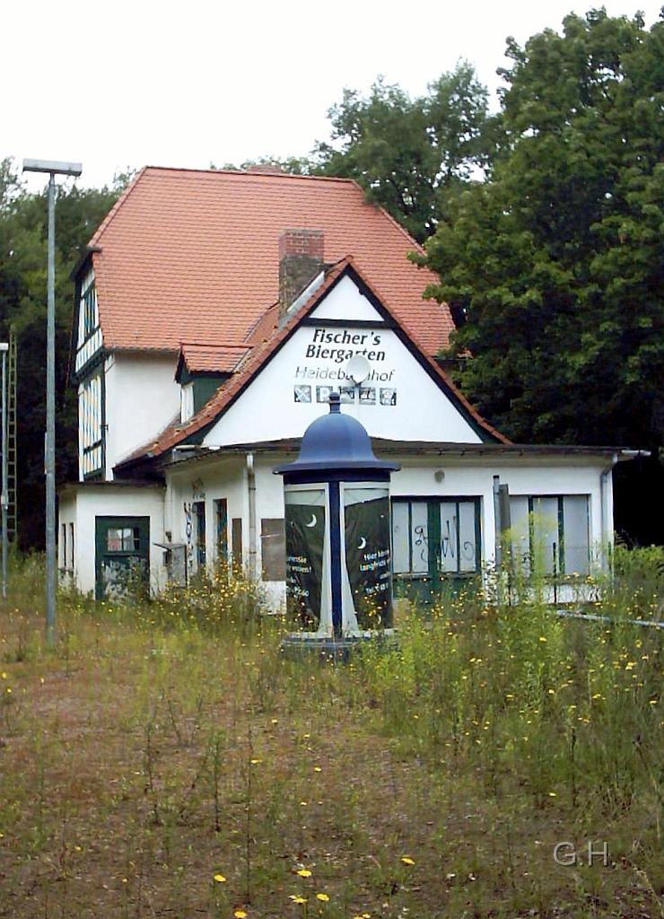 Bahnhof Heide_08.JPG - Der Bahnhof Heide, der ex. HHE, im Jahre 2005. Langsam holt sich die Natur das nicht mehr genutzte Gelände zurück. Der S-Bahnverkehr endet ja seit einiger Zeit in Halle-Nietleben. Die Tür von den kleinen Vorbau war der Zugang für den Schrankenwärter u. früher auch der Aufsicht. Dies war meines Wissens immer in einer Person vereint. Auch das verkaufen der Fahrkarten, bis zur Ablösung durch den Fahrkartenautomaten, gehörte zu den Aufgaben. Dabei kann es sein das zu DDR-Zeiten für den Fahrkartenverkauf direck jemand zuständig war. Wobei die letzten Jahren sich die Tätigkeit nur auf den Schrankenwärter beschränkte da es keine Aufsicht mehr gab.