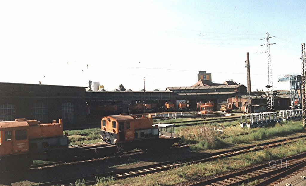 Halle_Bw_G.11.jpg - Im Jahr 1998 das Bw Halle G. Im Vordergrund am linken Bildrand stehen auf den Flachwagen die beiden im RAW Halle Umgebauten "Köf II" 199 003 und 199 004 von der Industriebahn Halle. Zu dieser Zeit ist der Betrieb der schmalspurigen Industriebahn längst eingestellt. Im übrigen einer dieser Köf ist jetzt im DB Museum Halle in der Berliner Straße abgestellt.